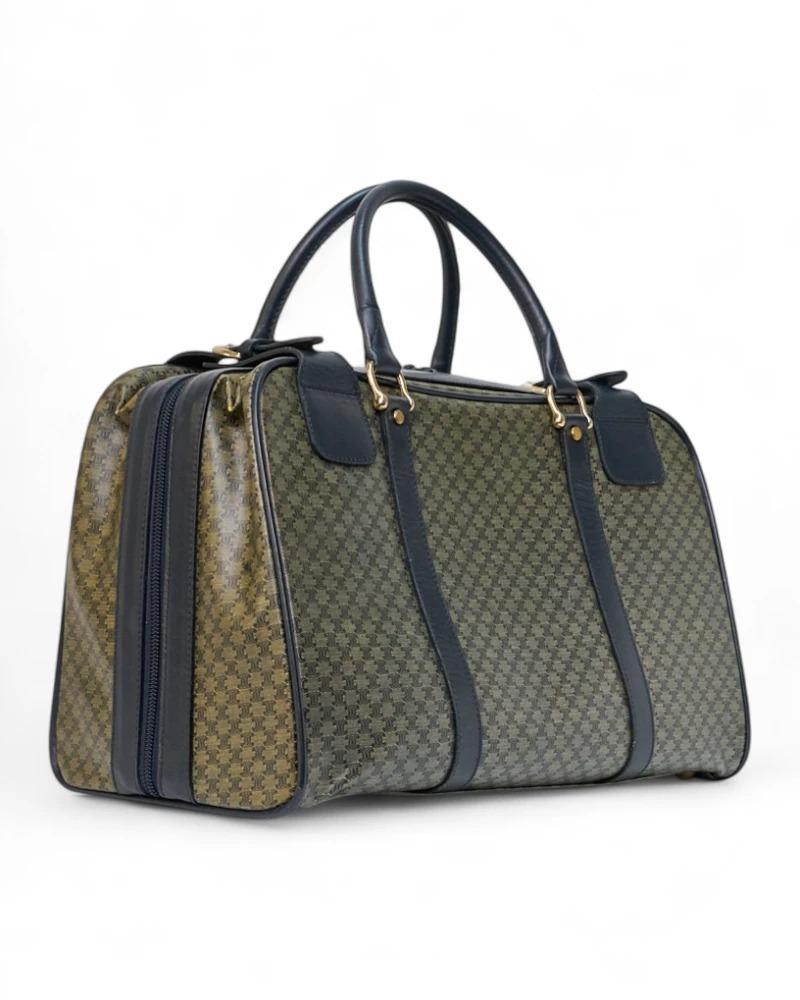 Die charakteristische Reisetasche von Celine, Größe 50, aus Canvas im Triomphe-Muster mit blauen Ledereinsätzen und goldenen Beschlägen. Ausgestattet mit einem halbrunden Reißverschluss mit Doppelschieber  und zwei verstellbaren Trägern, innen mit