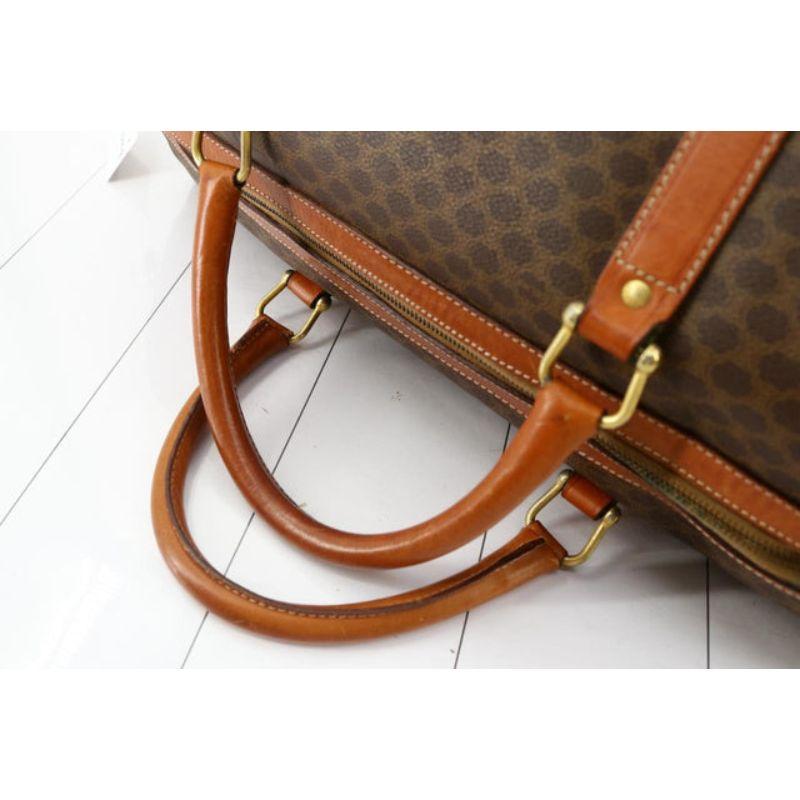 Celine Boston Bag features a brown Macadam Monogram PVC body with leather trim, gold-tone hardware, double rolled leather handles, a top zip closure, and an interior zip pocket. 
 

57579MSC

(L) 7,87