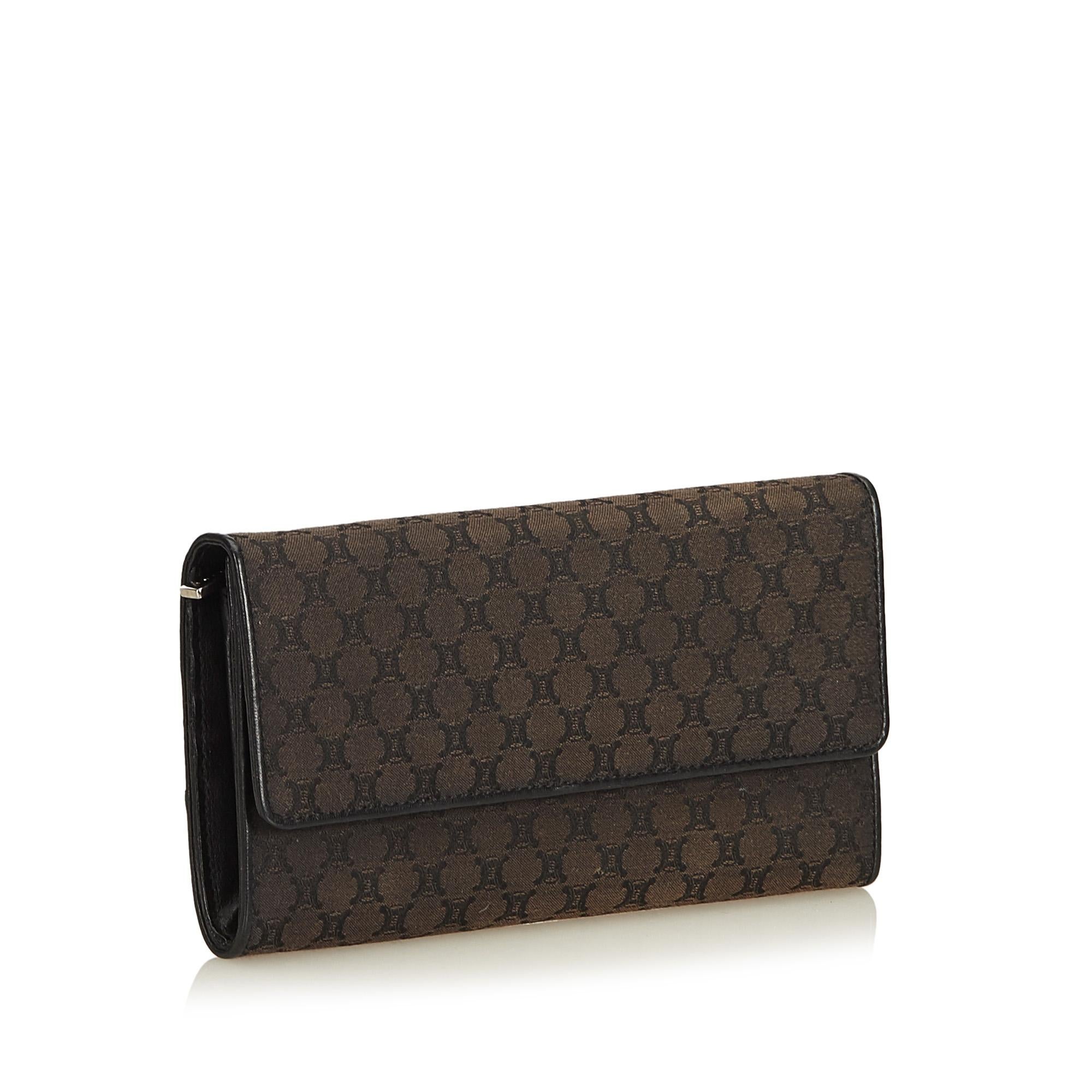 This long wallet features a jacquard body with leather trim, front flap with button clasp closure, and interior zip and slip pockets. It carries as AB condition rating.

Inclusions: 
Dust Bag
Box

Dimensions:
Length: 10.00 cm
Width: 19.00 cm
Depth: