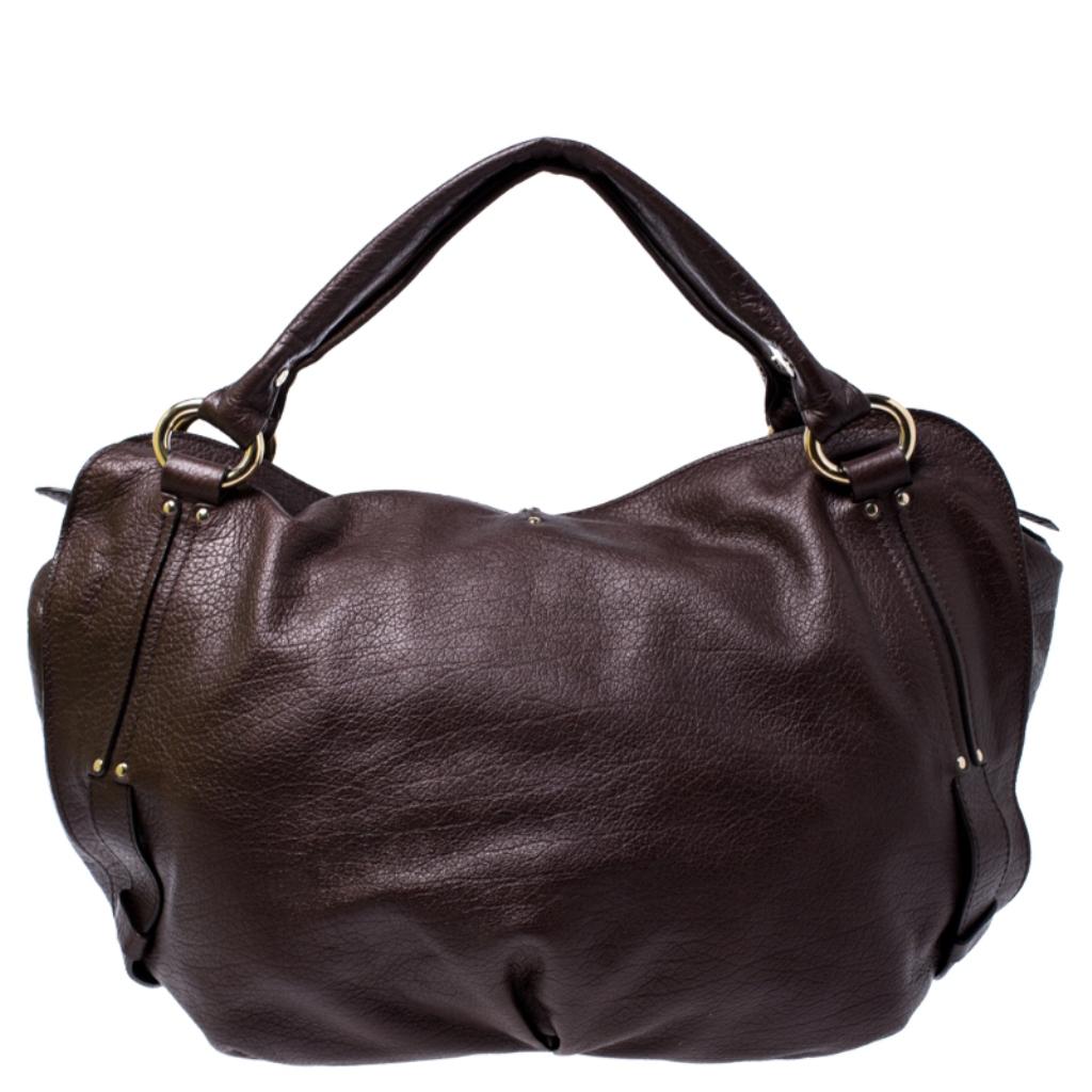 An everyday bag is made more feminine and elegant on this Celine Bittersweet hobo bag. Made from soft brown leather, this piece has a slouchy shape and gold-tone accents. With two top handles, this beautiful bag features a top zipper closure that