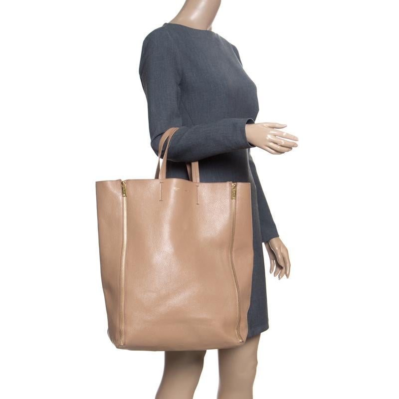 This Cabas tote brings a wonderful mix of fashion and function. This Celine tote is crafted from leather, detailed with vertical zipper gussets and held by two top handles. Also, the bag is equipped with a spacious leather interior for you to carry