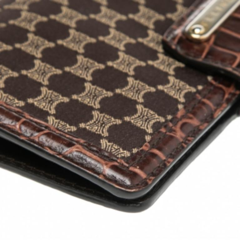 This French wallet coming from Celine is truly a chic, elegant accessory to own. It is made using brown Macadam canvas and croc-embossed leather on the exterior with gold-toned hardware highlighting its appearance. It has a leather-lined interior.