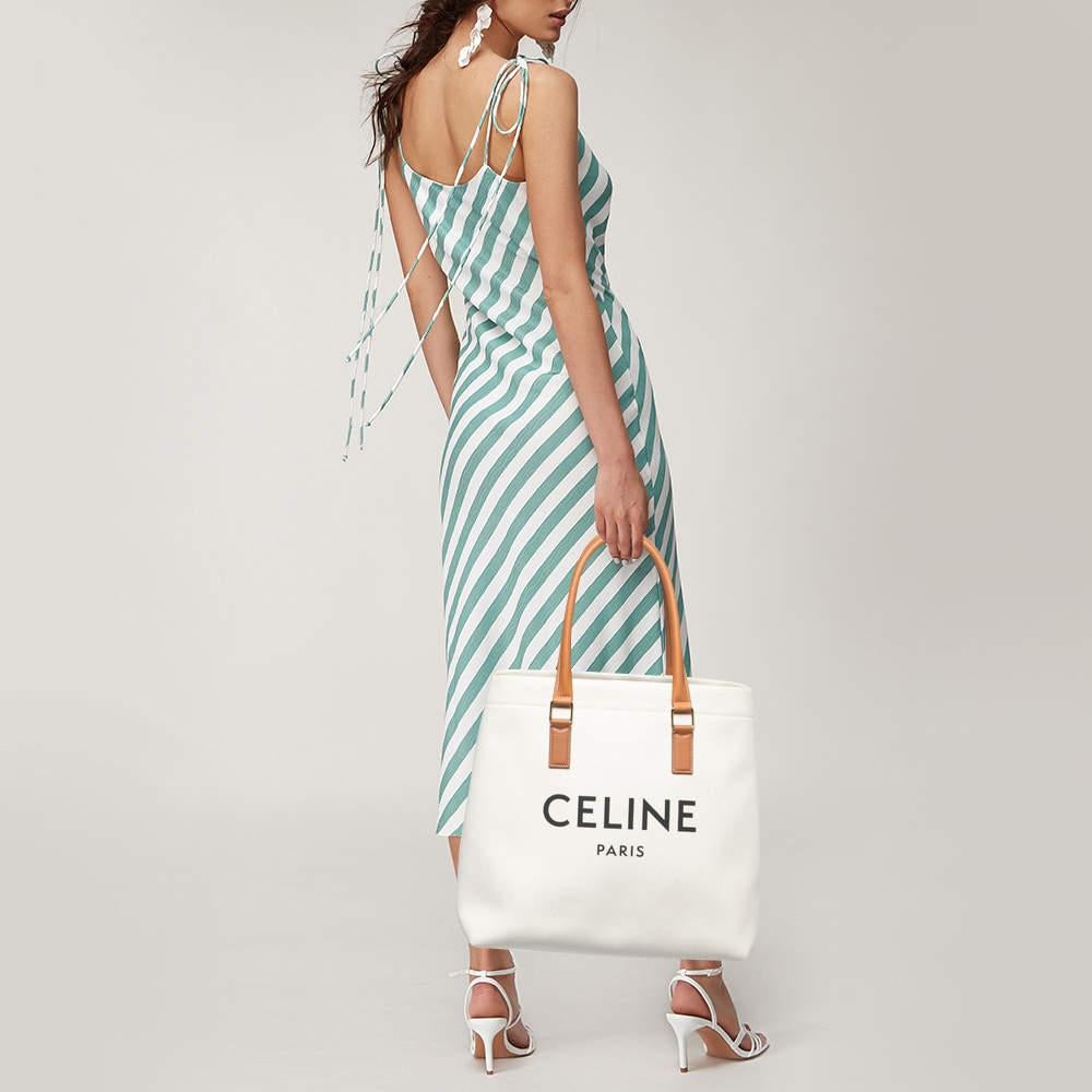 This gorgeous and chic tote bag by Celine will carry your essentials with ease. Attain a stylish look with this white bag by coordinating it with your outfit. This sleek and spacious canvas and leather bag are luxurious enough to elevate any