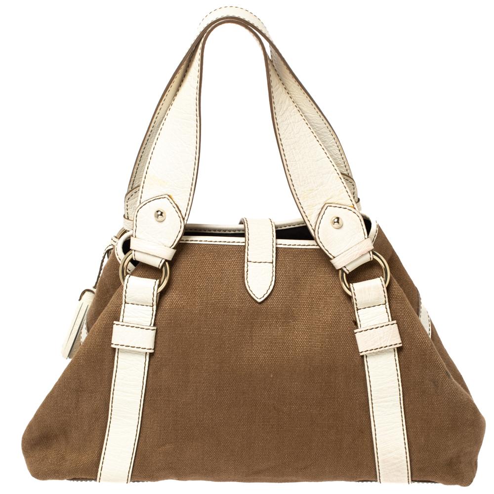 Ideal for everyday use, this Boogie tote is a Celine design. It is crafted from brown canvas and leather and equipped with a spacious fabric interior with a zip pocket. The lovely bag is complete with two handles, a relaxed shape, and gold-tone