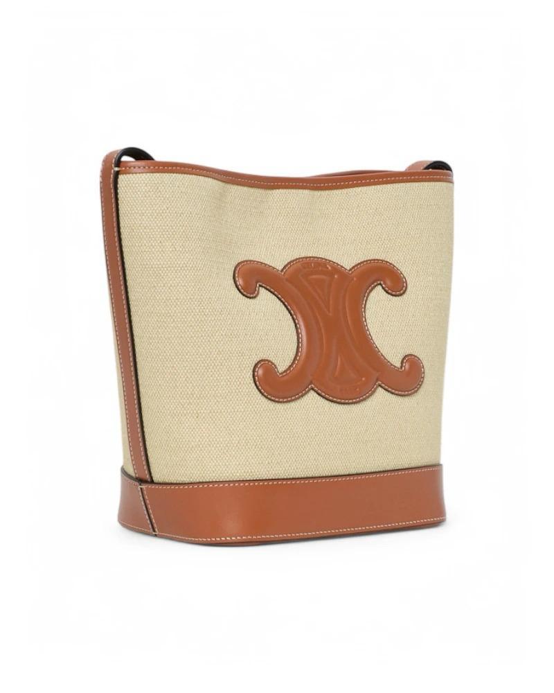 Celine signature bag, Triomphe line, Bucket model in size Small, made of beige canvas with leather leather trim and gold hardware. Equipped with an internal clip-button closure and internally lined with beige canvas, the bag is quite capacious.