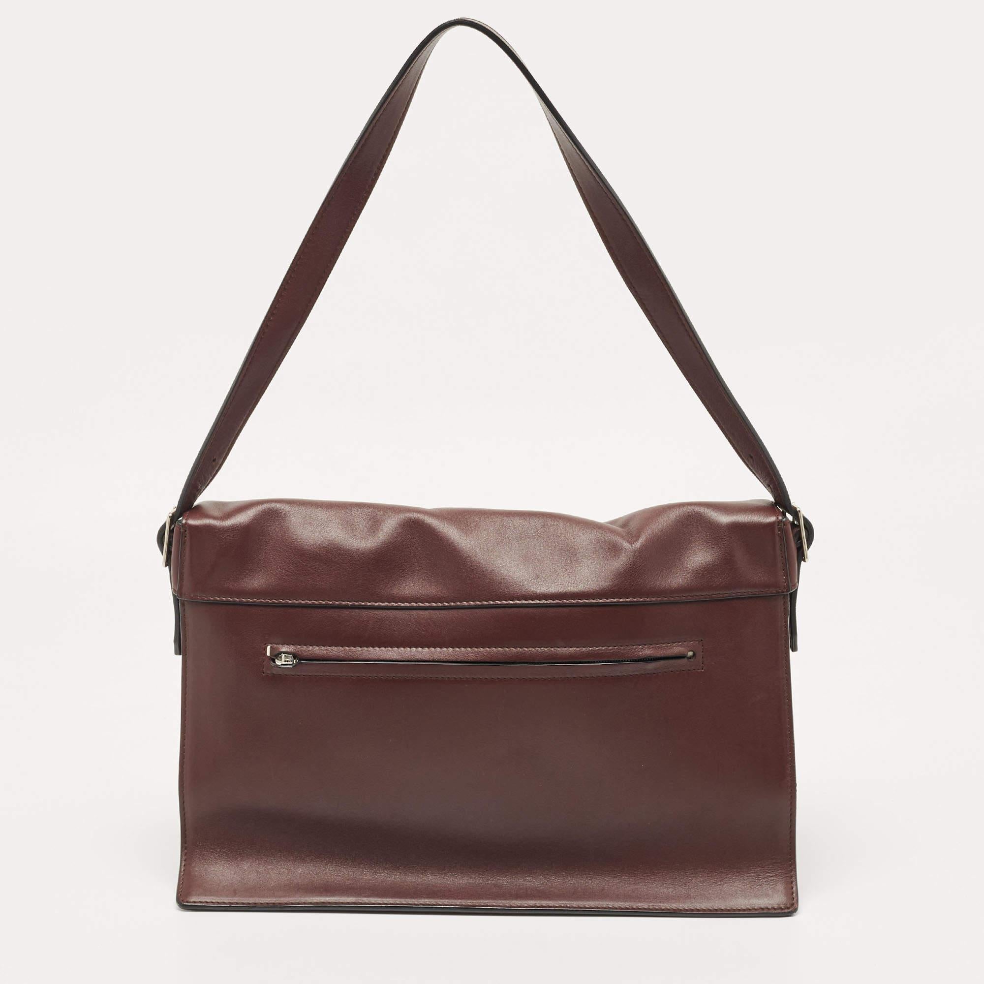 Crafted in burgundy leather and suede, this beautiful Diamond shoulder bag from Celine is easy to carry with casuals or formals. The envelope front flap opens with a silver-tone lock closure to a leather-lined interior with different compartments to