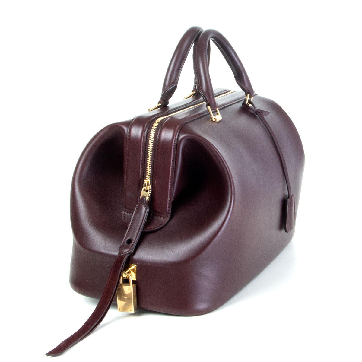 authentic Céline Frame Doctor Small handbag in deep burgundy calfskin. Opens with a zipper on top and is lined cognac calfskin with one open pocket against the back and six small open pockets against the front. Has been carried and is in excellent