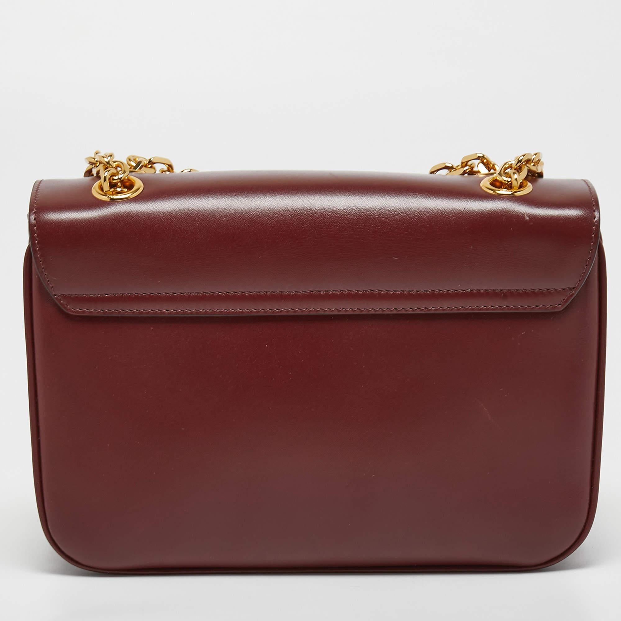 The Celine bag exudes elegance with its rich burgundy leather exterior. It features a sleek and structured silhouette, adorned with the iconic Celine logo in gold-tone hardware. The bag is equipped with a comfortable shoulder strap, making it a