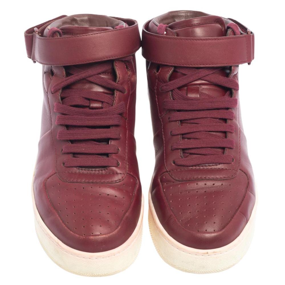 One's wardrobe is incomplete without a good pair of sneakers! If you're searching for a new addition, we suggest this one by Celine. These mid-top women's sneakers have been crafted using burgundy leather and styled with lace-up closure and velcro