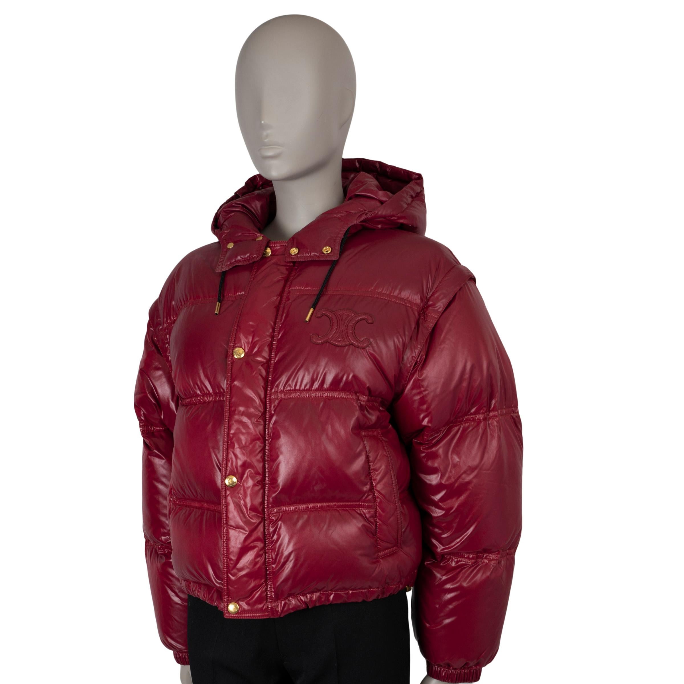 This 100% authentic Celine cropped puffer jacket in burgundy polyamide offers both style and versatility. Designed with detachable sleeves, it easily converts into a vest, allowing for multiple styling options. It features a Triomphe patch at the