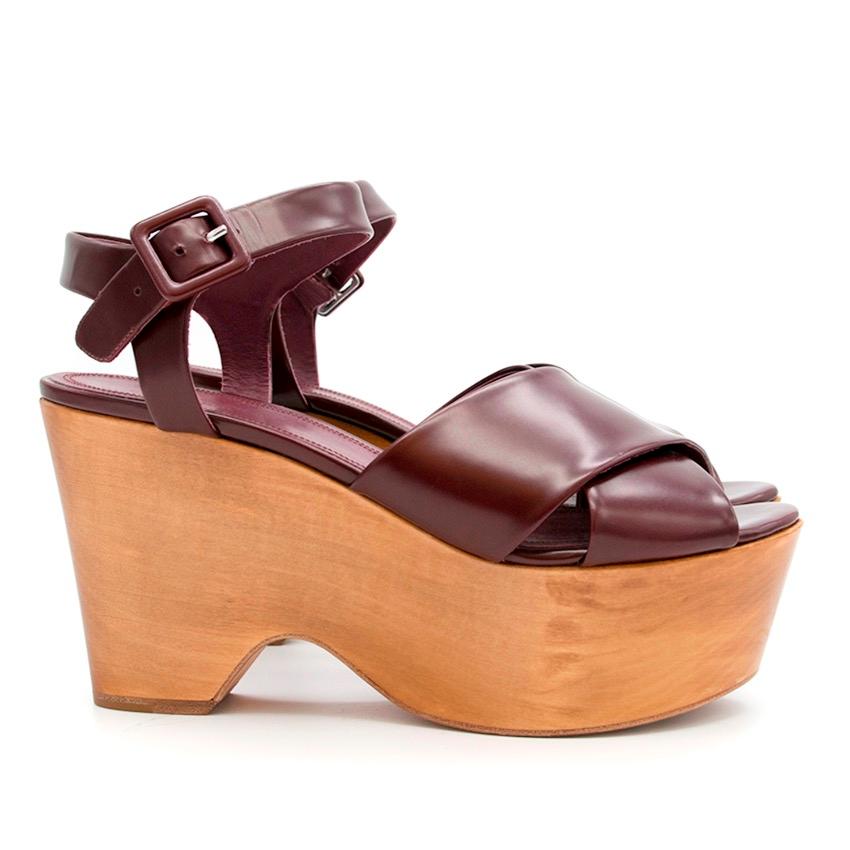 Celine burgundy wooden wedges with crossover front strap, almond shaped toe, contrast wooden wedge and ankle buckle strap. 

Made in Italy.

Please note, these items are pre-owned and may show signs of being stored even when unworn and unused. This
