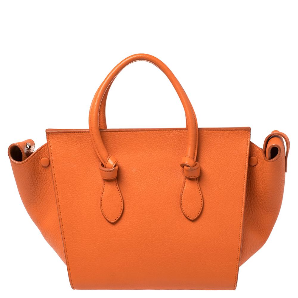 This Tie tote from Celine brings a wonderful mix of fashion and function. Expertly crafted from leather, it comes in a lovely shade of burnt orange with dual top handles and metal studs to protect the base. Made in Italy, it has a spacious interior