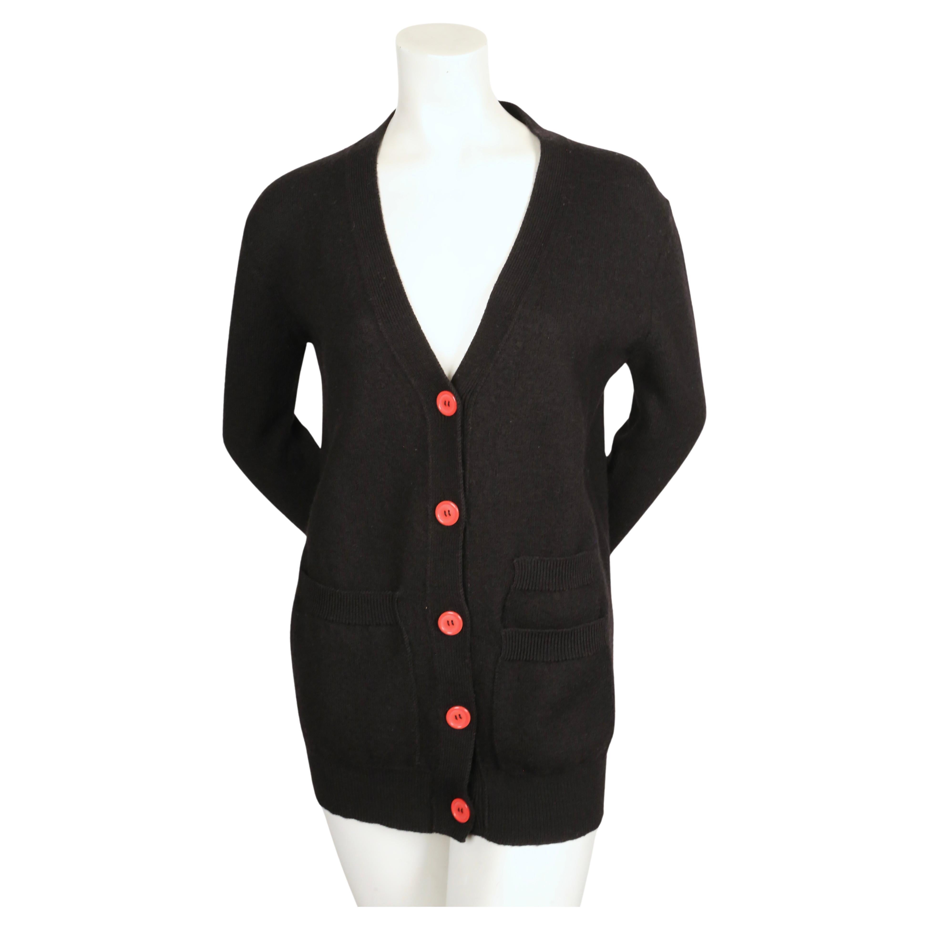 Black, boucle knit cardigan with extra long arms and red buttons designed by Phoebe Philo for Celine. Size 'XS'.  Approximate measurements: (unstretched): drop shoulders 19