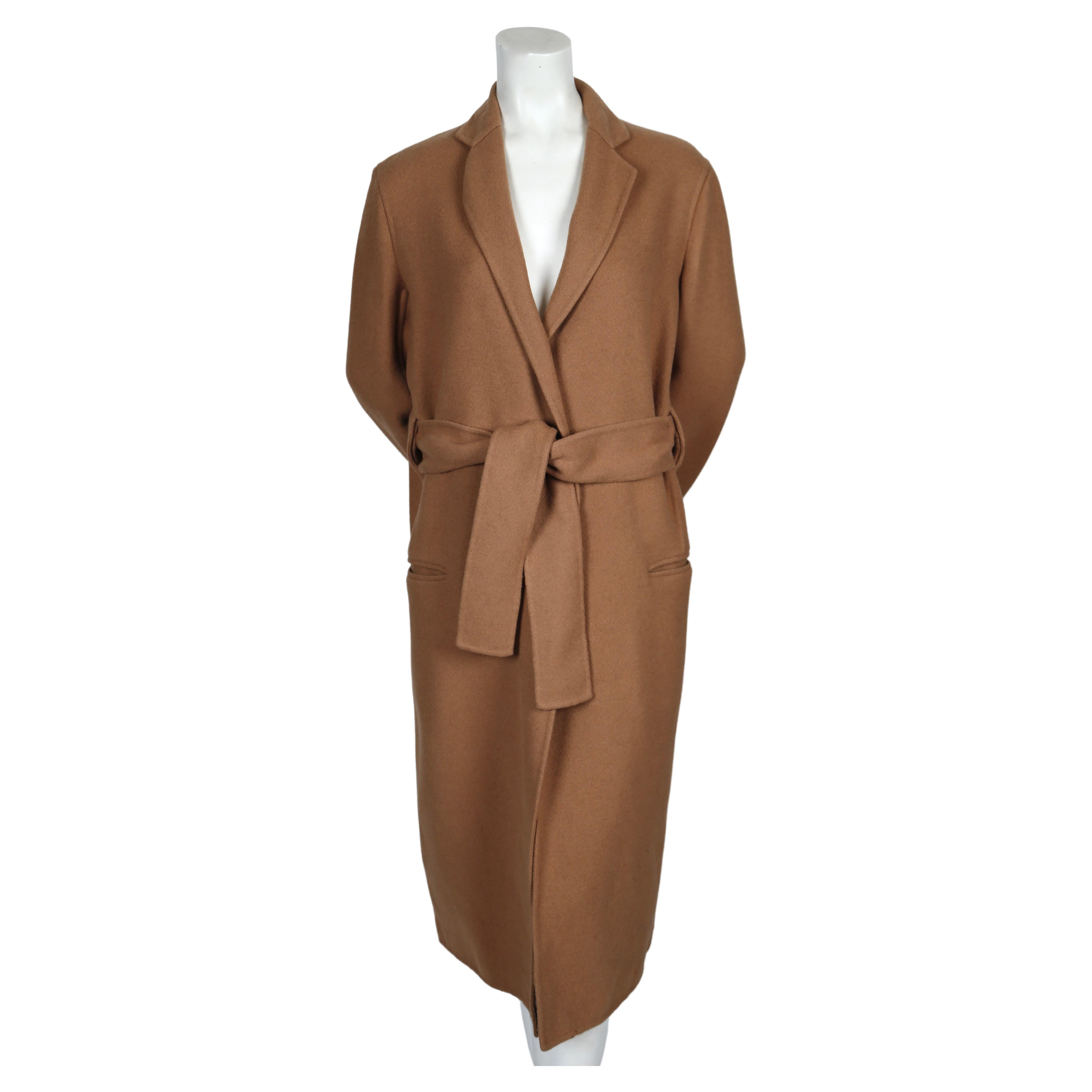 Very soft, camel double faced cashmere coat with wrap around belt designed by Phoebe Philo for Celine. Belt cleverly threads through the back of the coat for a clean line.  French size 38.  Approximate measurements: shoulder 18