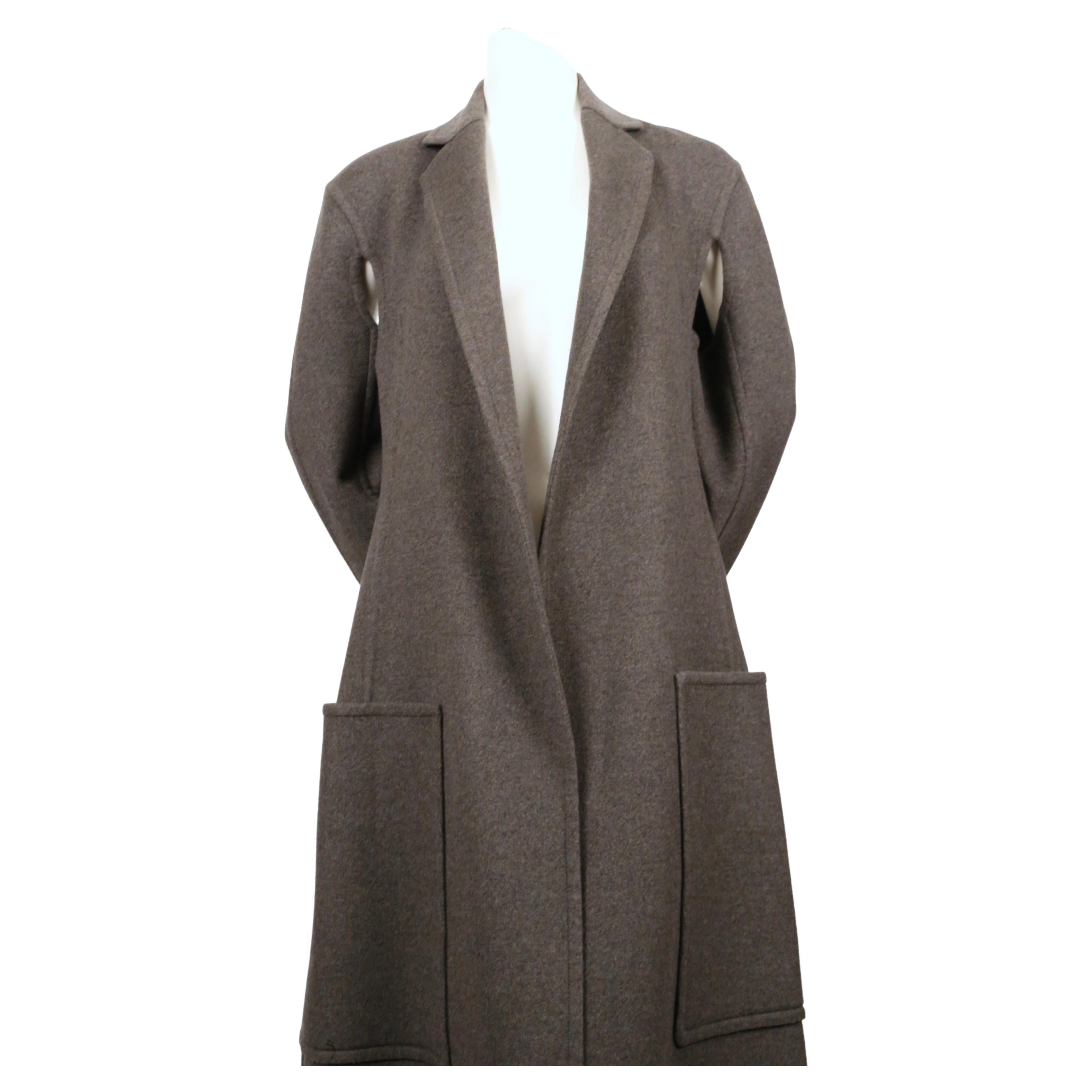 Very soft, heathered-grey, double faced cashmere coat with wrap around pockets and cutouts under arms designed by Phoebe Philo for Celine. French size 36.  Approximate measurements: shoulder 17