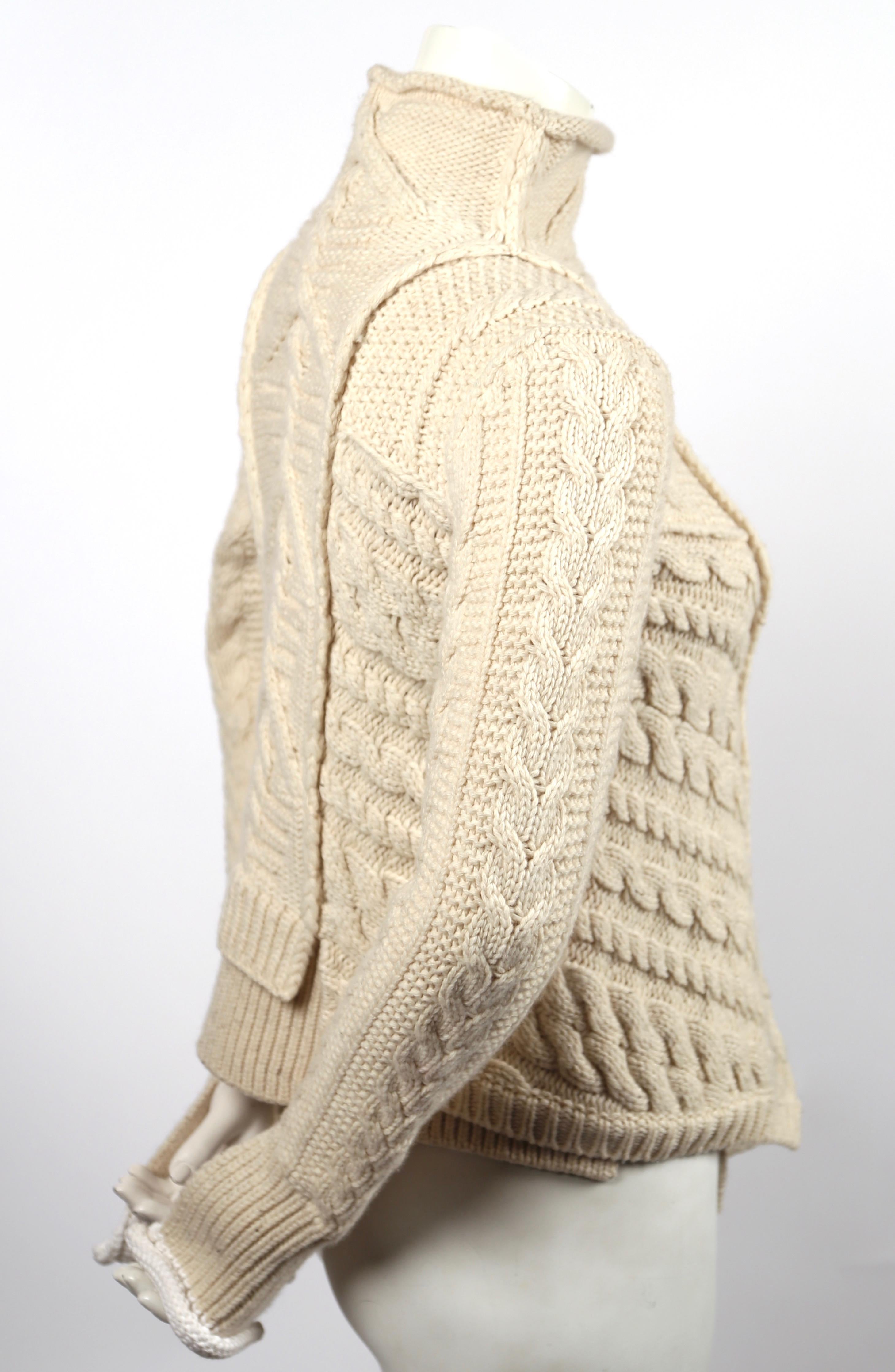 Very rare cream cable knit sweater with asymmetric hemline designed by Phoebe Philo for Celine dating to Fall of 2011. Labeled a size 'M' however this sweater runs small and best fits a size extra-small or small. Approximate measurements