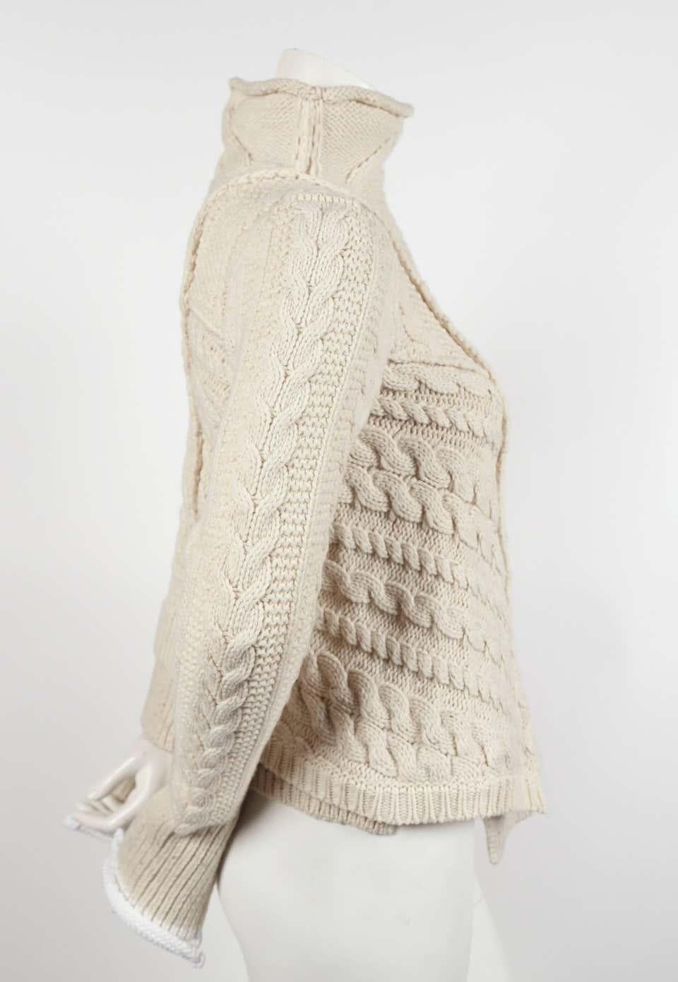 Very rare cream cable knit sweater with asymmetric hemline designed by Phoebe Philo for Celine dating to pre-Fall of 2011. Labeled a size 'M'. Fits a size small. Approximate measurements (unstretched): shoulder 14.5