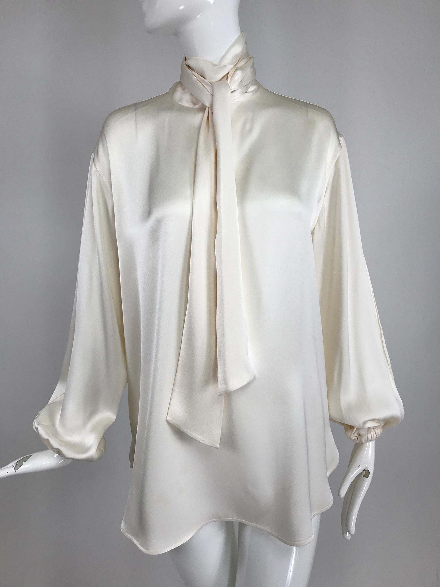Celine candle light silk satin oversize tunic top with full sleeves, deep front vent and neck ties. This beautiful blouse looks great belted or worn loose. Pull on blouse has yoke back long full sleeves with cased elastic cuffs, shirt tail hem is a
