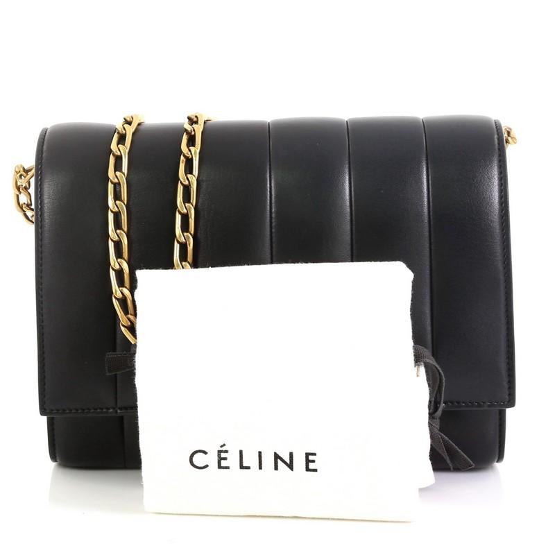 This Celine Chain Shoulder Bag Vertical Quilted Lambskin Medium, crafted in black leather, features a chain-link strap, quilted design and gold-tone hardware. Its flip-lock closure opens to a black leather interior divided into three compartments