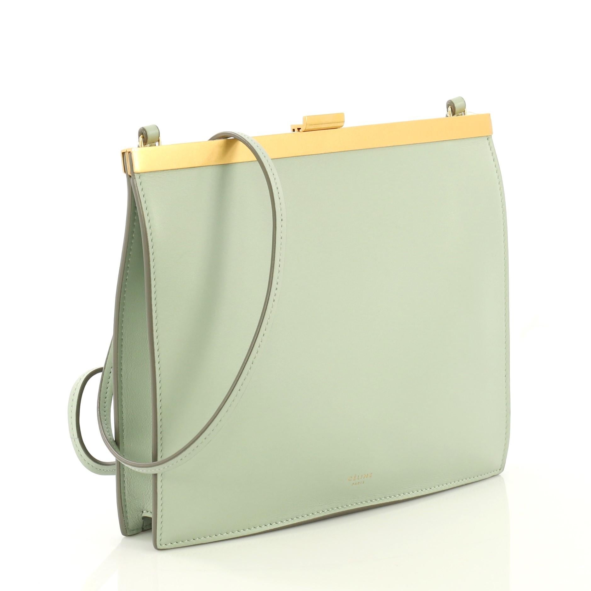 This Celine Clasp Crossbody Bag Leather Mini, crafted in green leather, features a slim leather shoulder strap, stamped Celine logo, framed top, and gold-tone hardware. Its clasp closure opens to a brown leather interior with slip pockets.