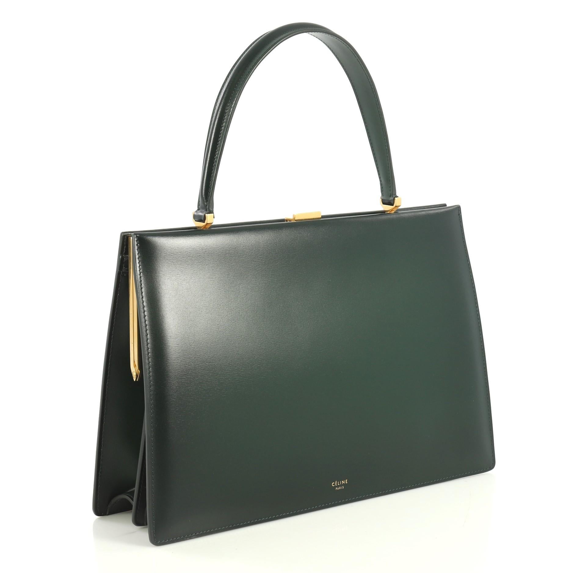 This Celine Clasp Top Handle Bag Leather Medium, crafted in green leather, features a leather top handle, stamped Celine logo, framed top, and aged gold-tone hardware. Its clasp closure opens to a purple leather interior divided into two