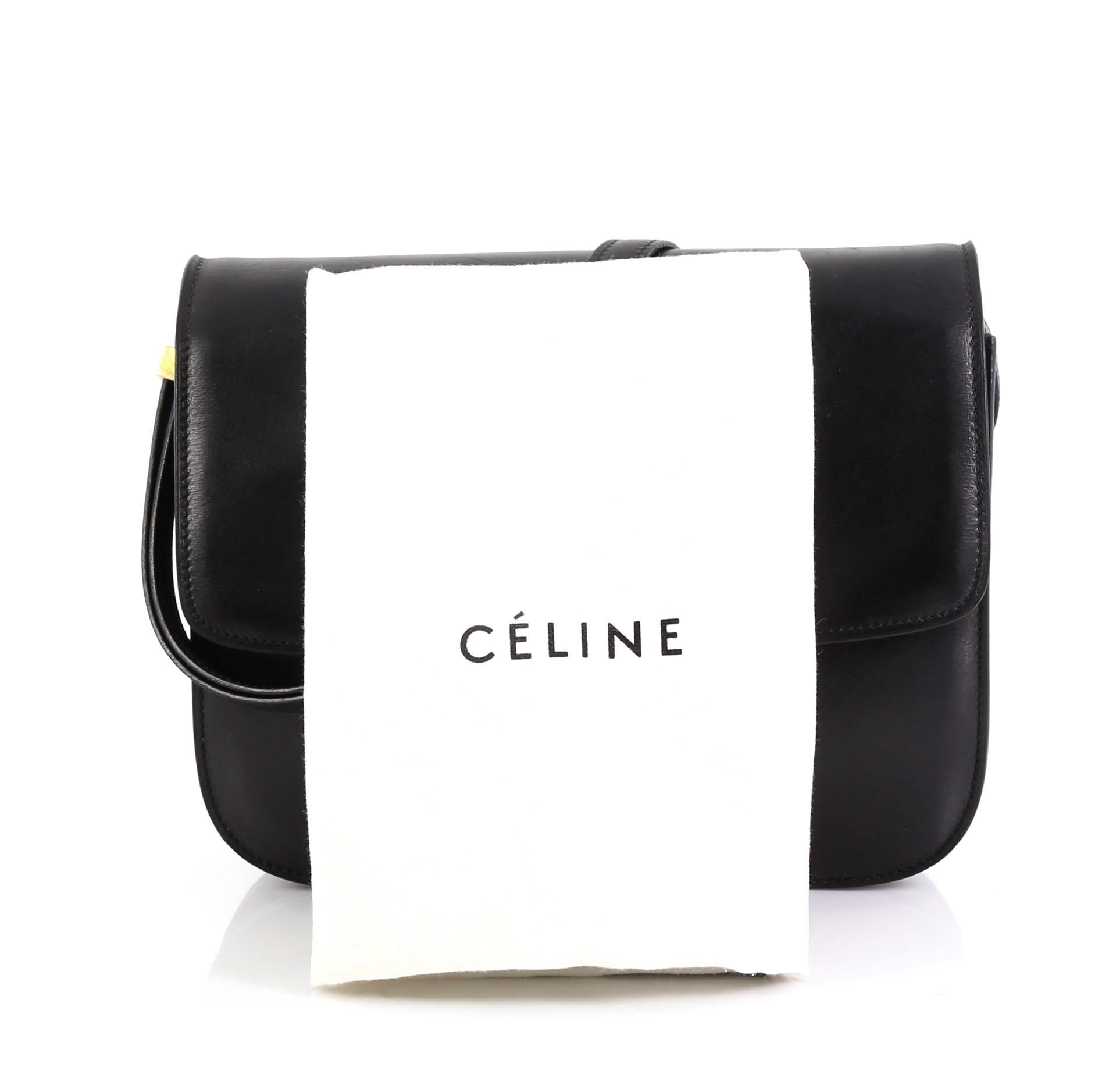 This Celine Classic Box Bag Smooth Leather Medium, crafted from black smooth leather, features a long adjustable strap and gold-tone hardware. Its push-tab closure opens to a black leather interior with two open compartments, zip compartment and
