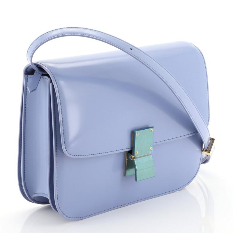This Celine Classic Box Bag Spazzolato Calfskin Medium, crafted from blue leather, features adjustable strap and aged gold-tone hardware. Its clasp closure opens to a blue leather interior with zip and slip pockets. 

Estimated Retail Price:
