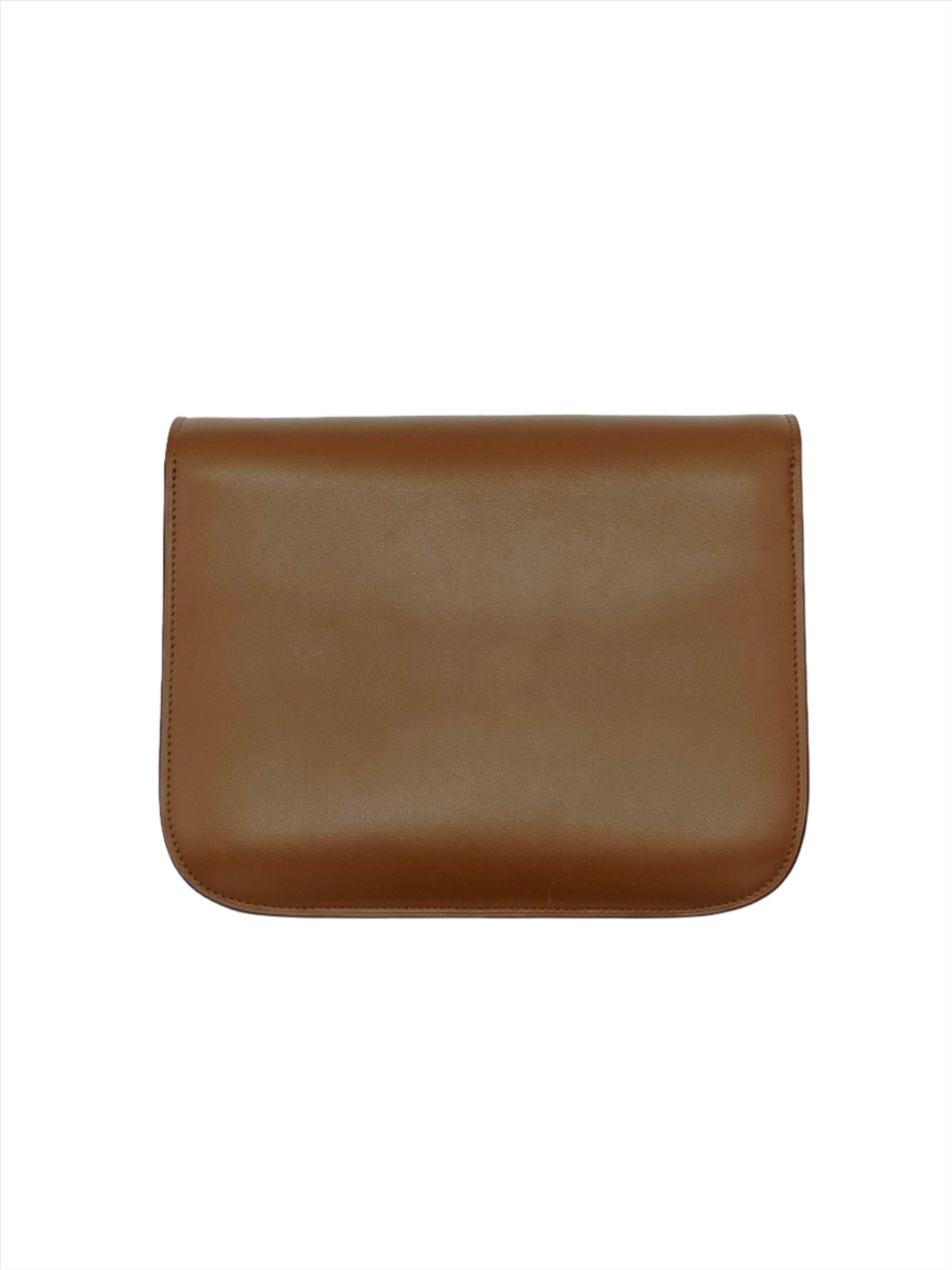 The Celine Box features the structured, minimalist design for which the brand has become known. The leather shoulder strap can be adjusted to a variety of lengths or detached to be carried as a clutch with a unique snap closure, and simple gold