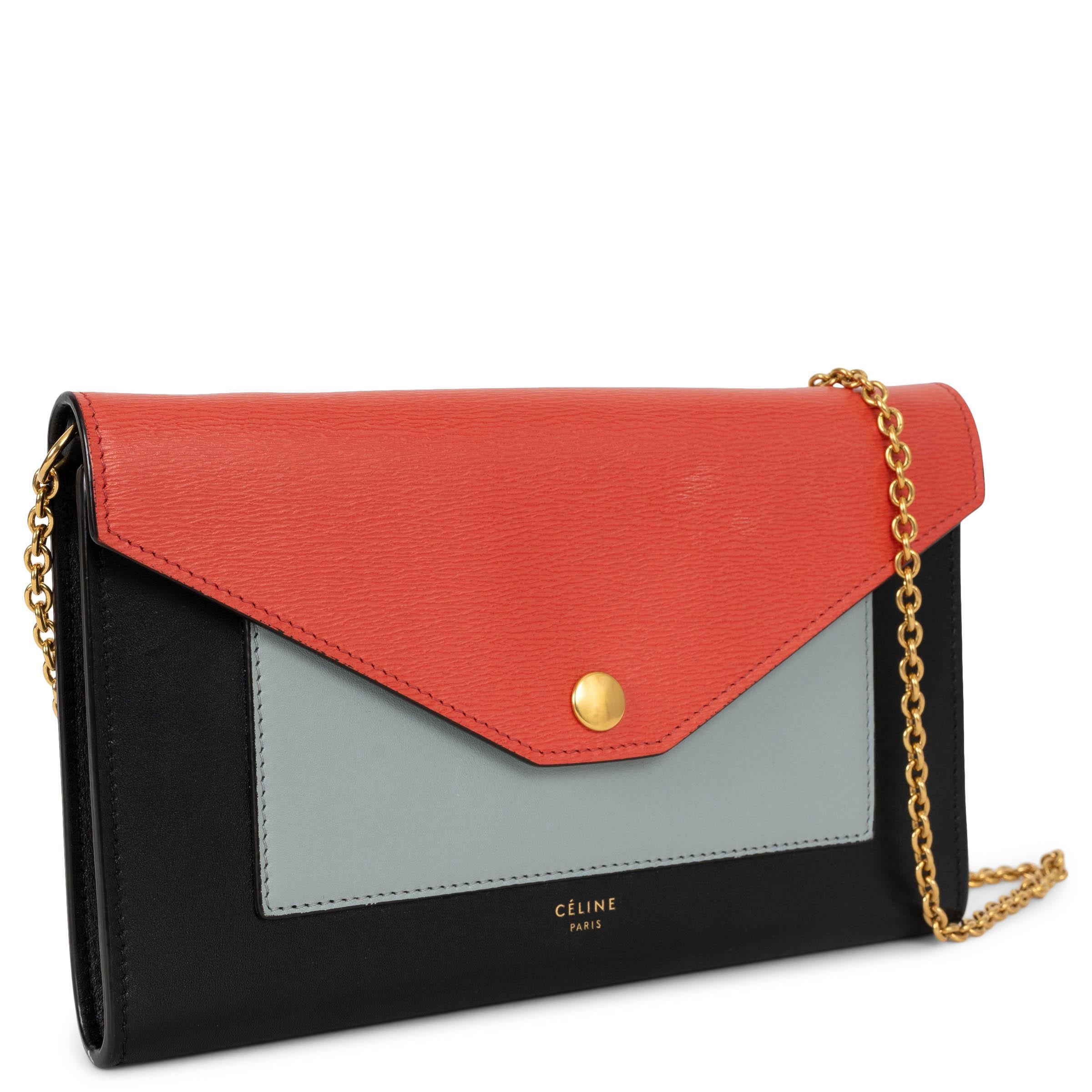 This 100% authentic Celine Pocket Large Flap on Chain WOC bag is crafted in smooth navy and airforce blue calfskin leather with a contrasting coral-red textured leather flap. The tri-color colorblock design is elevated by gold-tone hardware and a