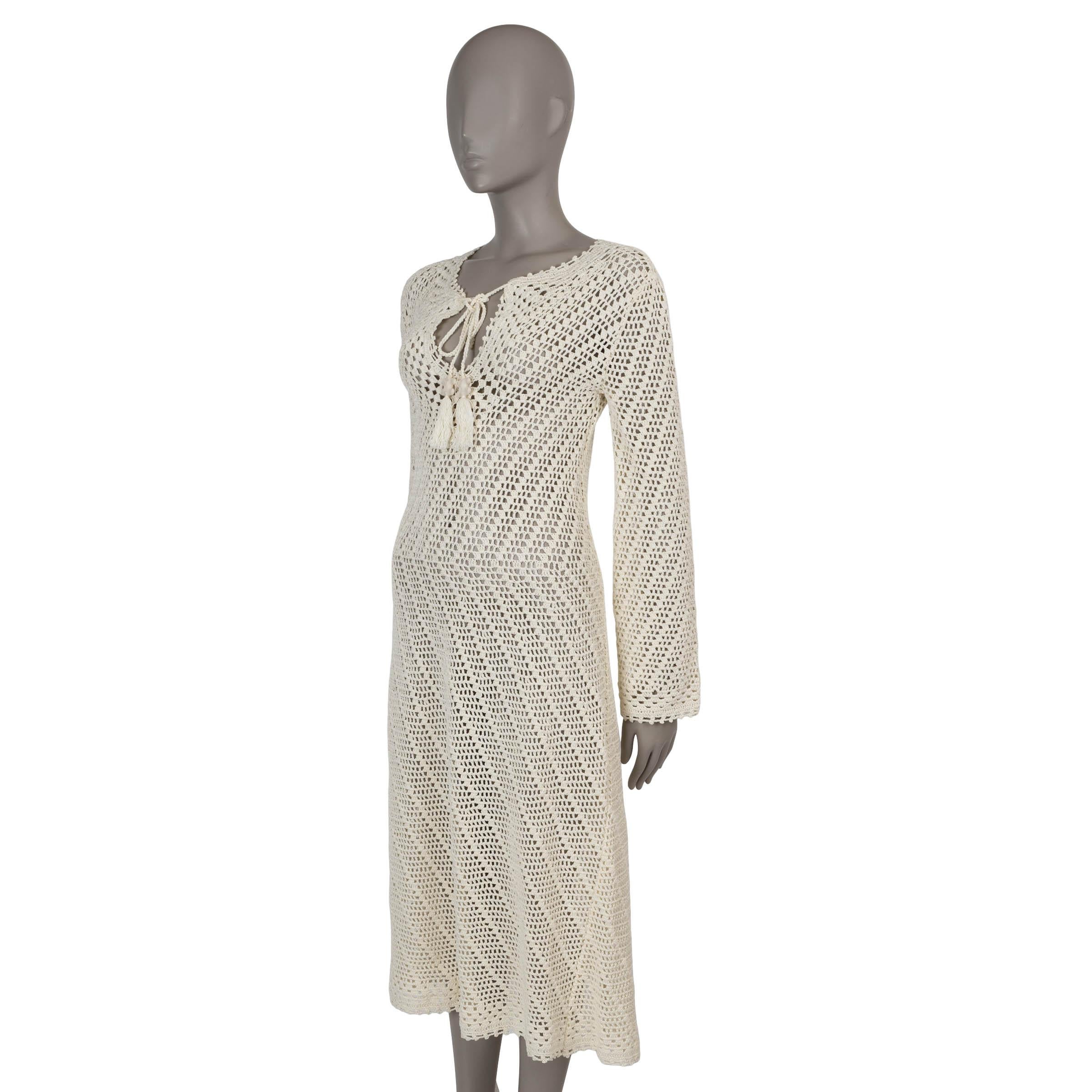 This 100% authentic Celine dress in cream crochet cotton embodies effortless bohemian elegance. Designed with a fit-and-flare silhouette, it features a midi length, long sleeves, and a split neckline adorned with long Triomphe-embellished tassels.
