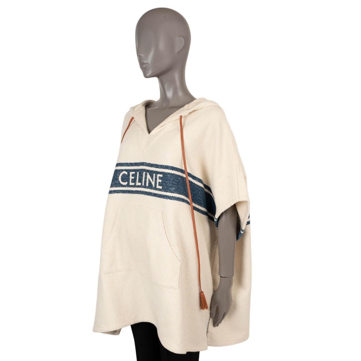 100% authentic Celine Baja cape poncho in cream and navy cotton (91%) and polyamide (9%). The design features a hood, a faux drawstring in cognac brown leather with tassels and kangaroo pocket on the front. Has been worn once or twice and is in