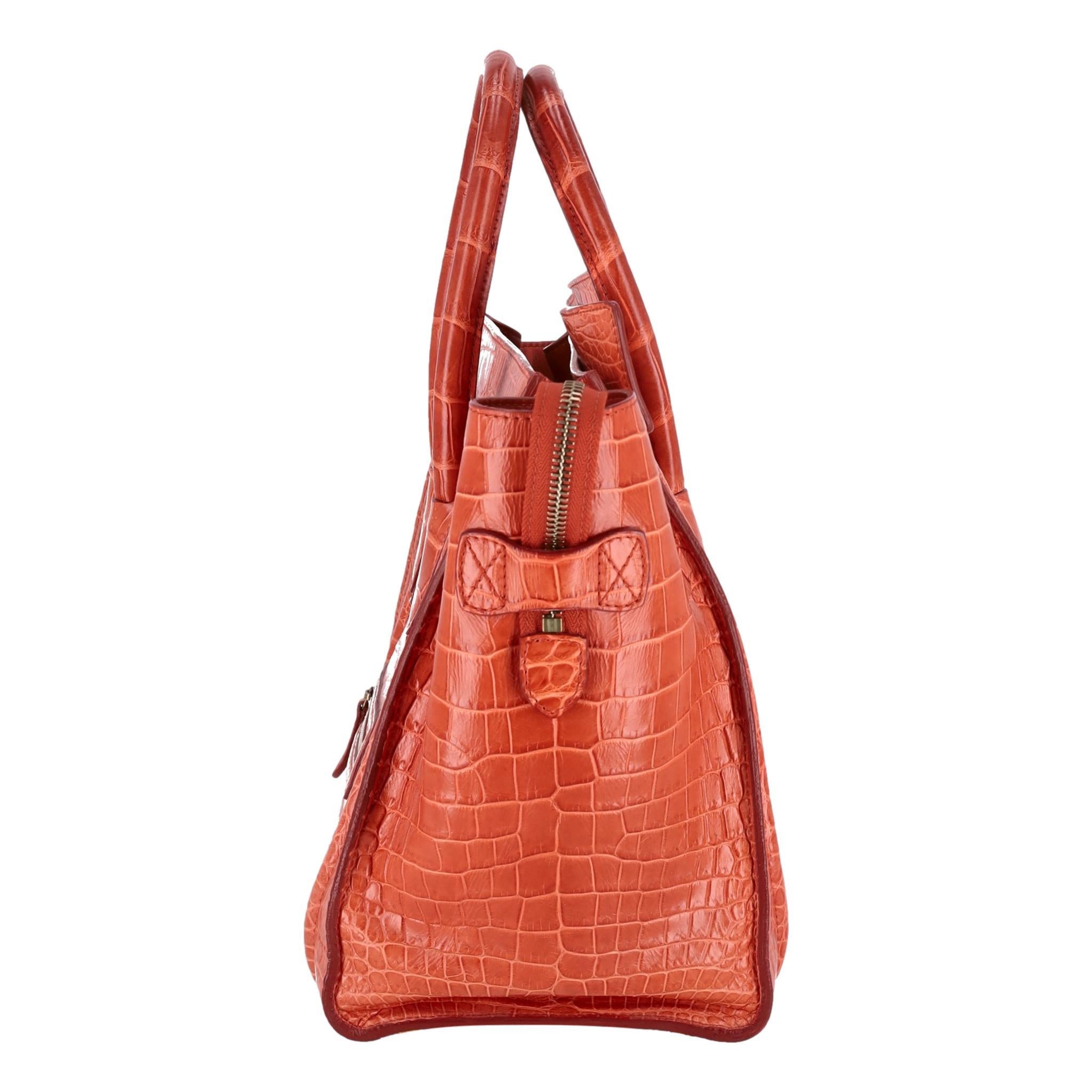 Celine Crocodile Skin Micro Luggage Handbag

Luxury tote bag in bright orange exotic skin with gold hardware.

Featuring dual rolled top carry handles, detailed stitching and zipped top closure 

leading to a leather interior.  Embossed in gold is