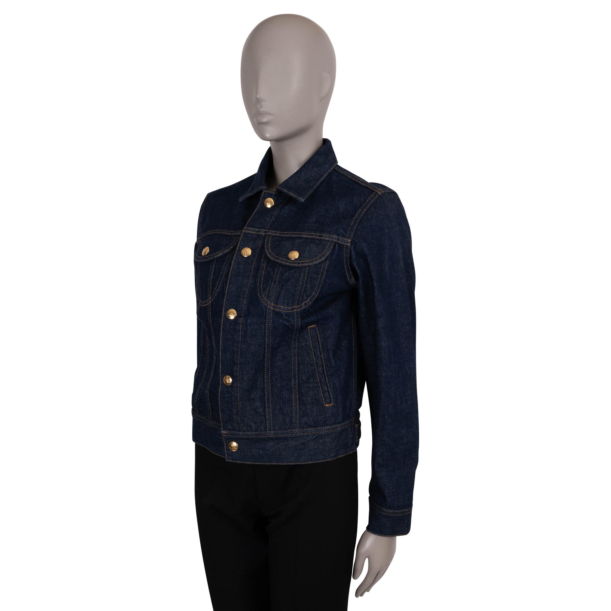 This 100% authentic Celine trucker denim jacket is crafted in raw washed dark blue cotton with contrasting orange stitching. Designed with a classic fit, it features a shirt collar, two rounded flap chest pockets, two welt pockets, buttoned cuffs,