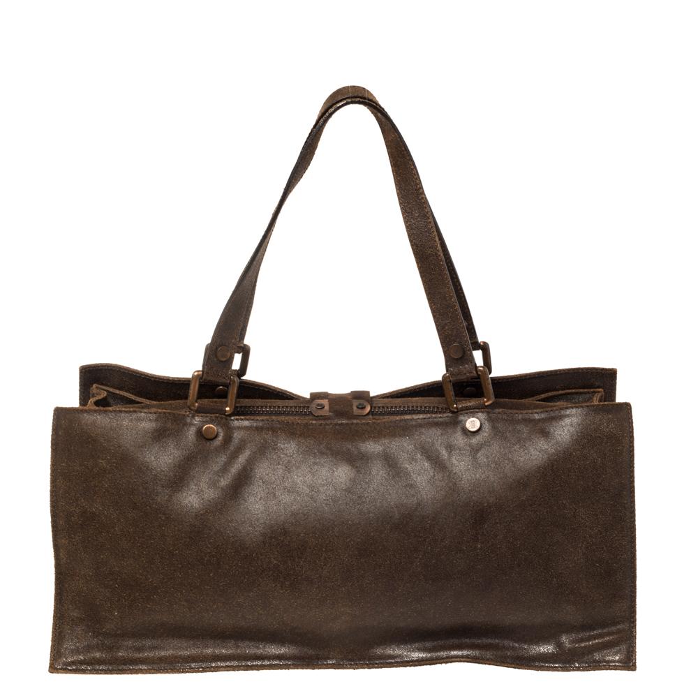 Unique and finely made, this dark brown bag from Celine can help you outline your looks with sophistication. It is crafted from nubuck leather and features a front cross over buckle flap that is accented with rose gold-tone hardware. It opens to a