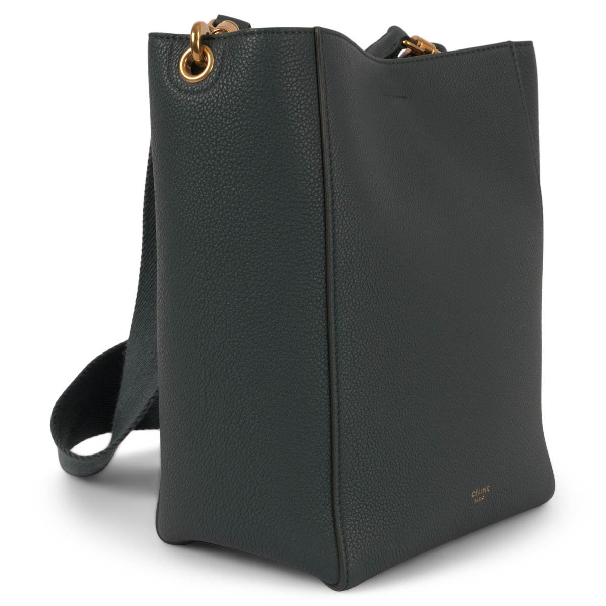 100% authentic Céline Sangle Small Bucket Bag in dark green grained calfskin with gold-tone hardware. The design features a wide detachable canvas strap and is lined in petrol green suede with one zipper and one flat pocket against the back. Closes