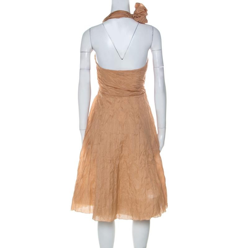 This beauty of a dress from Céline is beautifully tailored from a silk blend. The dress has a short length, a halter neckline and an open back. It is covered in dusty orange shade and ruched texture all over. You can wear the dress with a pair of