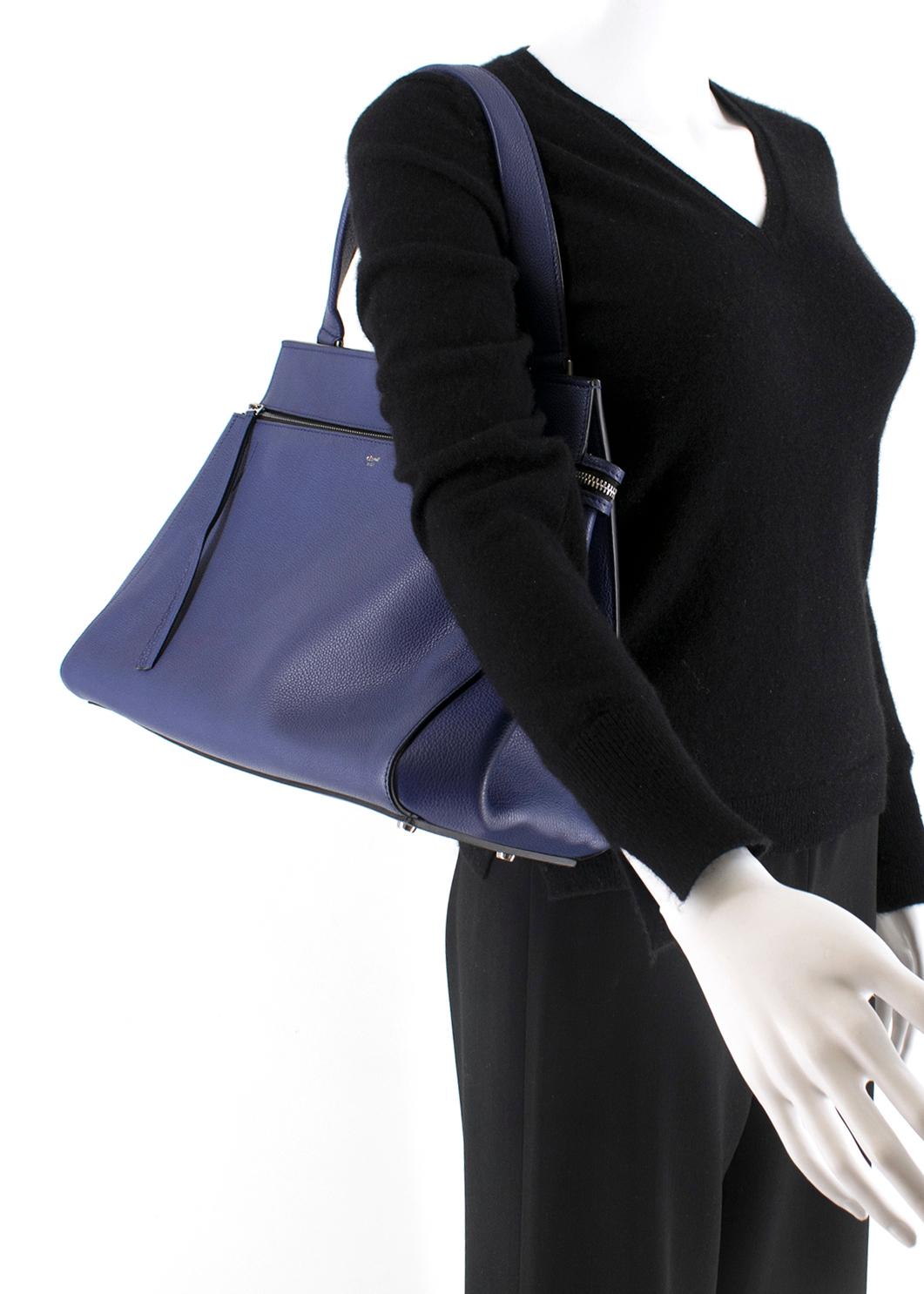 Celine Edge Indigo Blue Tote Bag 

-Medium size
-Single handle 
-Outer Snap Closure Pocket
-Single Zip Closure
-Fully lined in black leather
-One zip inside pocket, two large slip pockets
-Silver tone hardware 

Please note, these items are