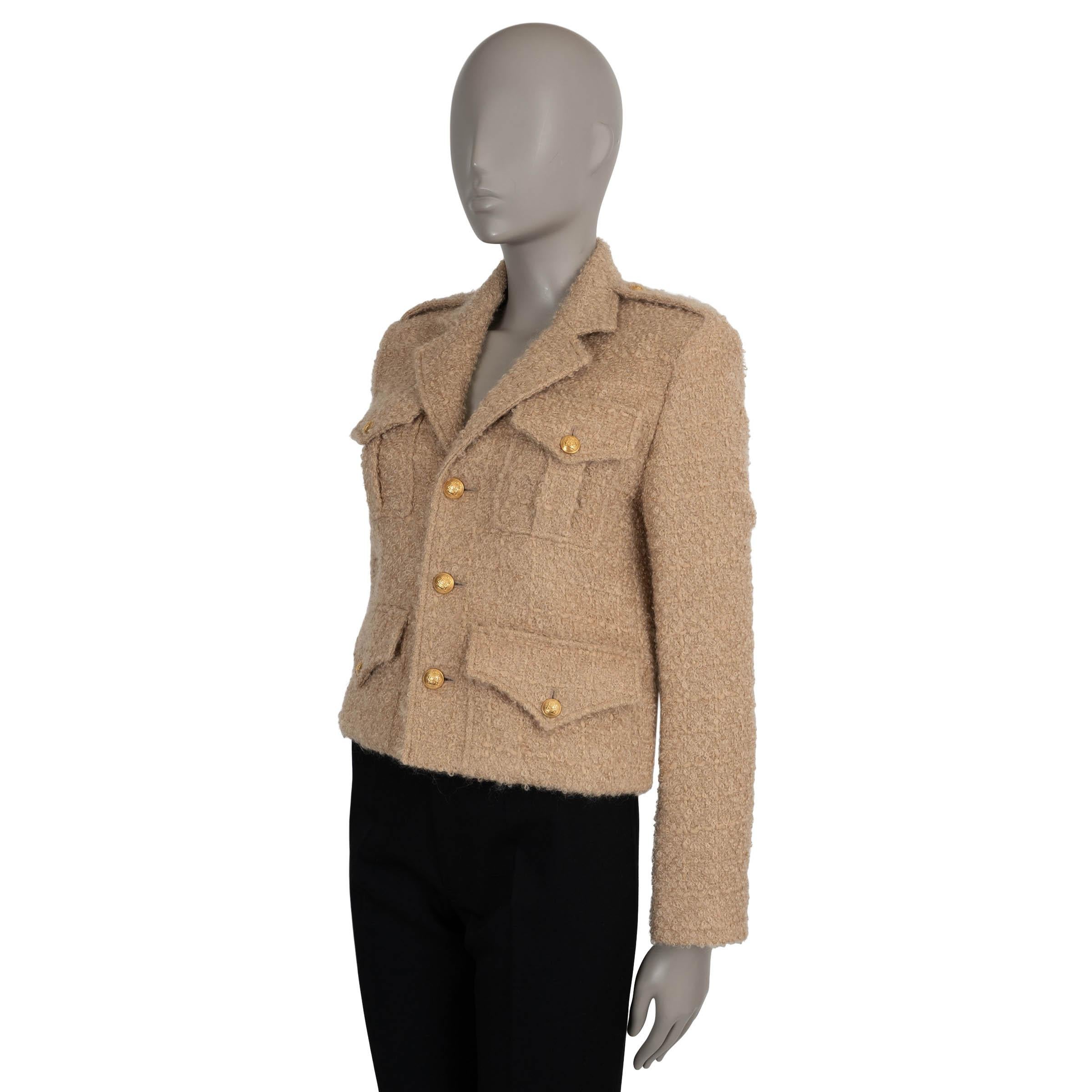 Questa giacca militare Celine Chasseur 100% autentica in tweed bouclé beige (54% mohair, 37% lana vergine, 9% nylon) offre un equilibrio sorprendente di struttura e raffinatezza. La silhouette cropped è arricchita da pad per un look forte e