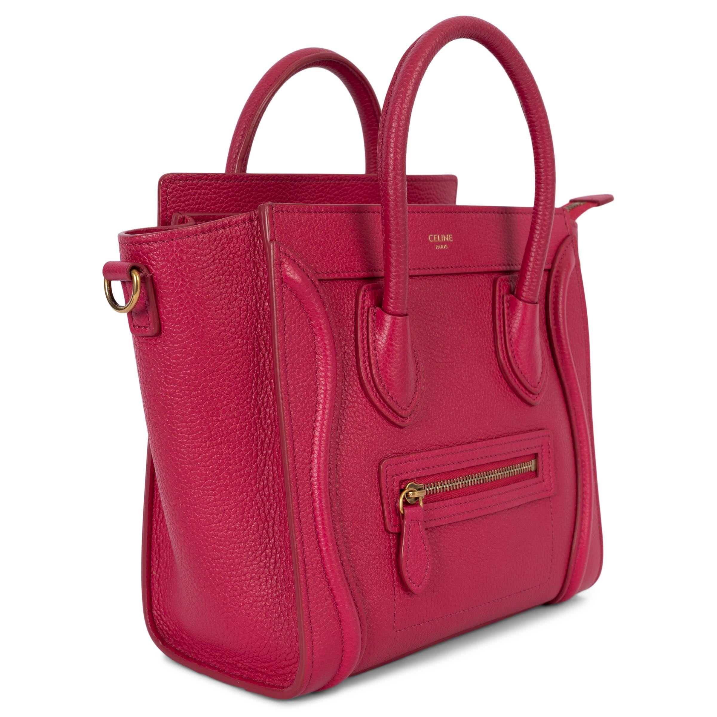 100% authentic Celine Nano Luggage cross body tote bag in fuchsia pink drummed calfskin featuring antique gold-tone hardware. Opens with a zipper on top and is lined in pink suede with one open pocket against the back. The design features a zipped