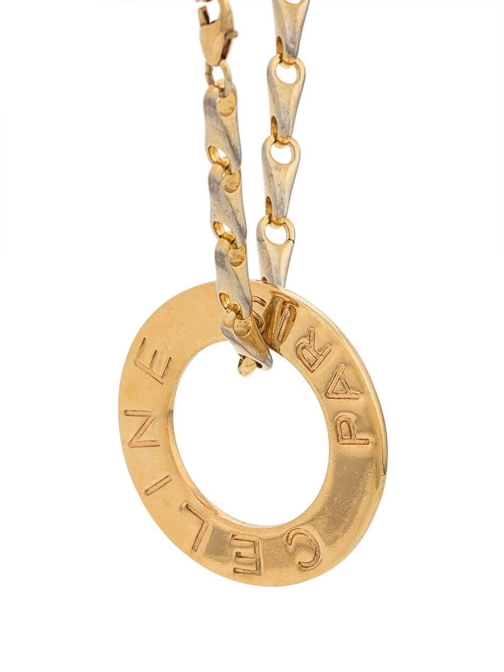 Crafted from antique gold-toned metal hardware, this elegant, pre-owned necklace from Céline is a unique piece that adds a touch of classic sophistication to any outfit with an elegant disc pendant, an engraved logo and a lobster clasp closure. This