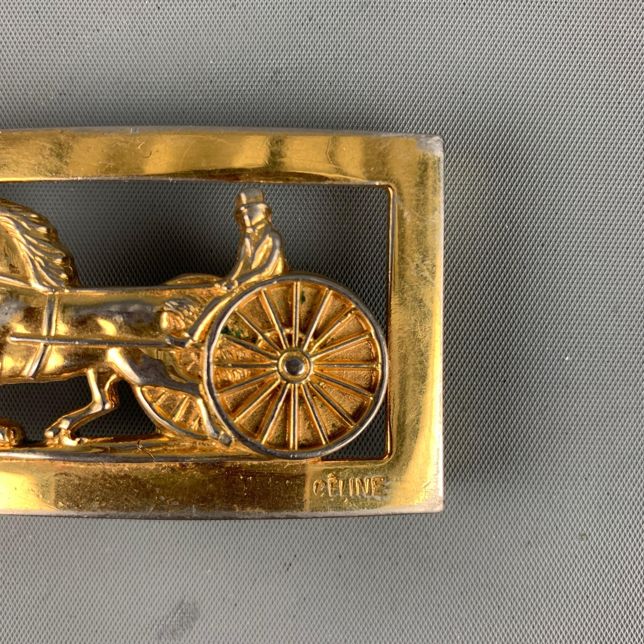 CELINE
belt buckle in a gold tone metal featuring a horse drawn carriage design, and belt loop.Good Pre-Owned Condition. Moderate signs of wear. 

Measurements: 
  9 cm. x 6.5 cm.
  
  
 
Sui Generis Reference: 129569
Category: Belt Buckle
More