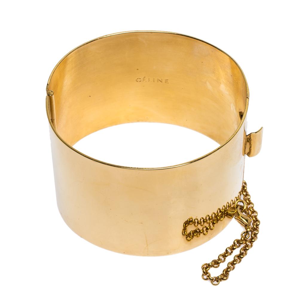 This cuff bracelet from Céline will be your new favourite statement accessory. It has a minimalist design rendered in a gold-tone body. This wide cuff bracelet is comfortable to wear and will complement your versatile fashion choices effortlessly.

