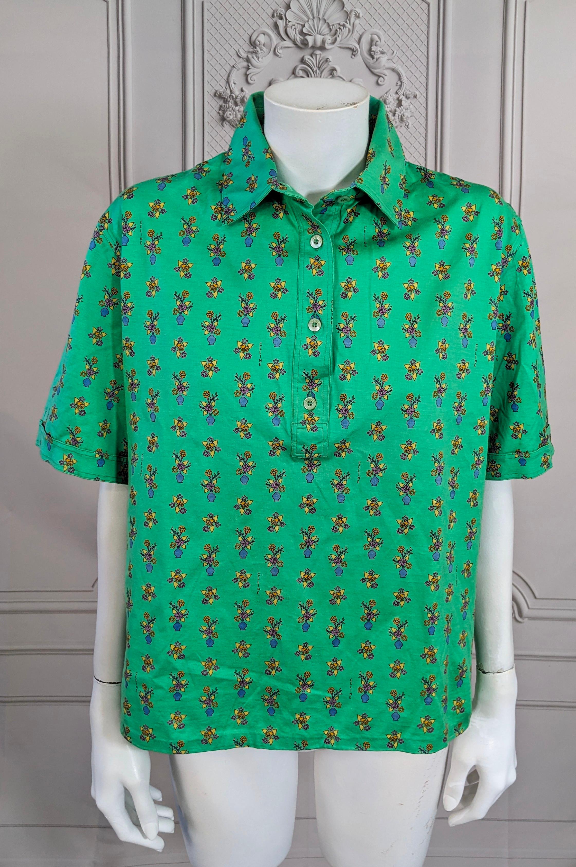 Celine cotton short sleeved polo. Of bright green cotton lisle overall printed with floral bouquets and flower vases, in yellow, red, blues and greens. Logo signed Celine inside the print. Mother of pearl Celine buttons. Very Good Condition. Size 46