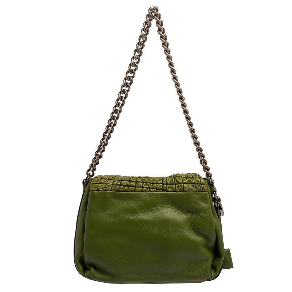 A flap bag in green leather highlighted by a turn lock on the front. Held by a shoulder chain and lined with fabric, this bag is a fine brew of quality and sophistication. Add a touch of classic charm to your look with this Watch Me bag by