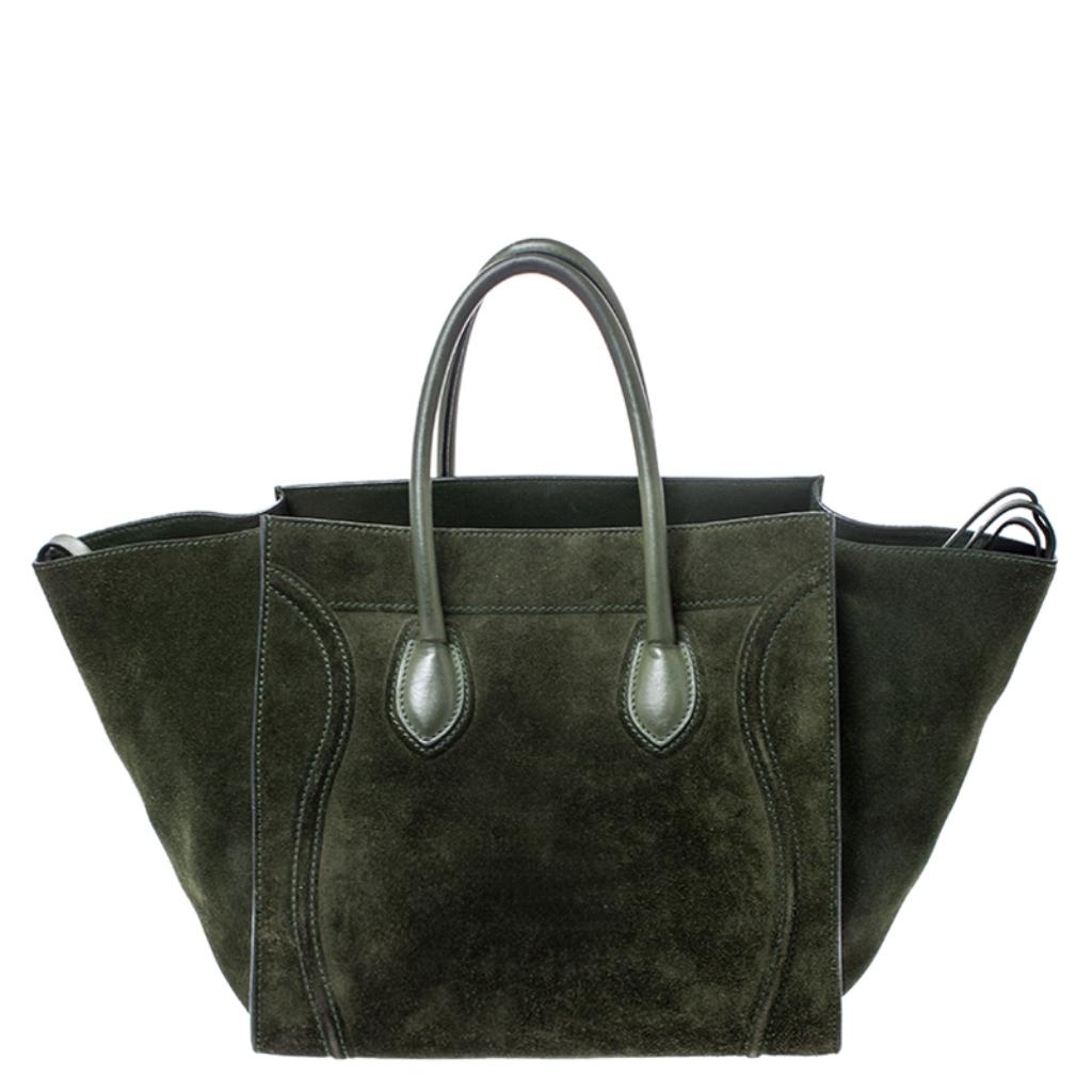 Celine released the Phantom as a newer version of their successful Luggage model. Unlike the Luggage toes, the Phantom has an open top, wider wingspans, and a braided zipper pull. We have here the one in suede. It has two top handles, a green shade,