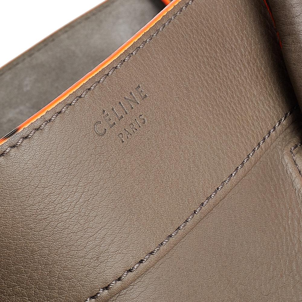 Celine released the Phantom as a newer version of their successful Luggage model. Unlike the Luggage toes, the Phantom has an open top, wider wingspans, and a braided zipper pull. We have here the one in leather. It has two top handles, a grey