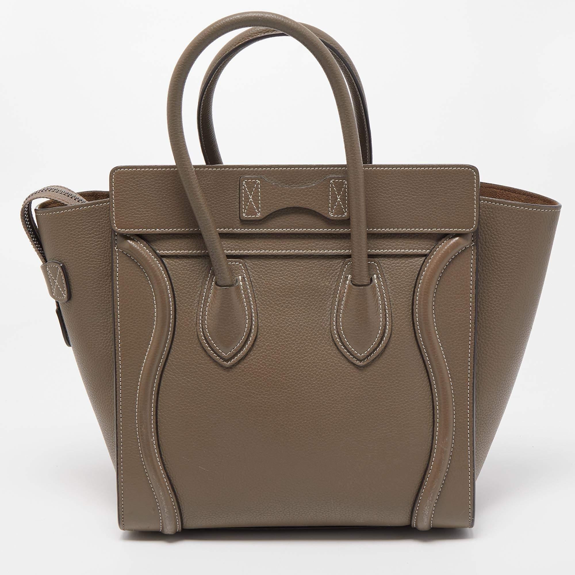 The Luggage tote from Celine is one of the most popular handbags in the world. This tote is crafted from leather and designed in a grey hue. It comes with rolled top handles and a front zip pocket. The bag is equipped with a well-sized leather