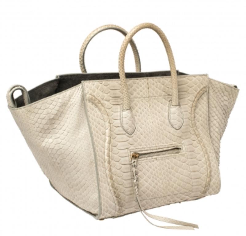 Celine released the Phantom as a newer version of their successful Luggage model. Unlike the Luggage toes, the Phantom has an open-top, wider wingspans, and a braided zipper pull. We have this one in python leather. It has two top handles, a lovely