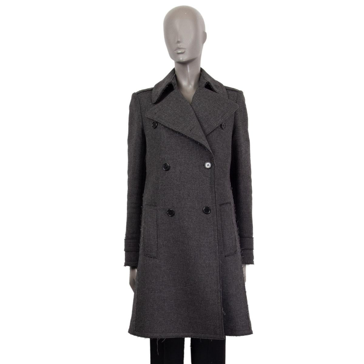 Céline double-breasted coat in dark gray wool (100%) with fringed hemlines, peak-collar, A-line, long sleeves and two slit-pockets in the front. Sleeves lined in off-white cupro. There has been some repair on the inner seam lining with some