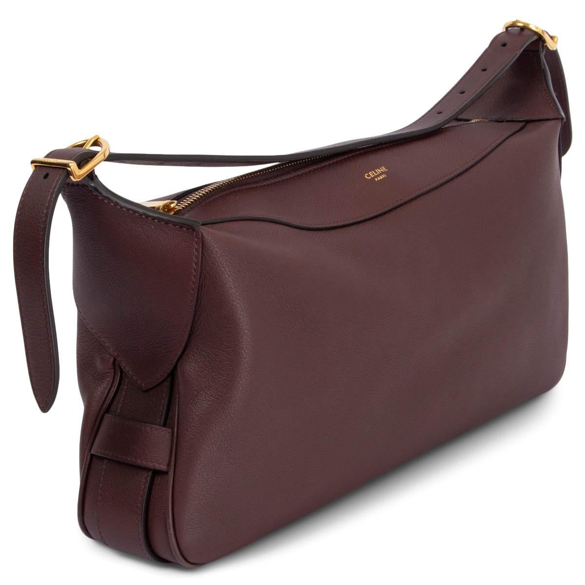 Sac à bandoulière Celine Medium Romy 100% authentique, en cuir de veau souple hickory (bordeaux), doté de ferrures dorées. Il s'ouvre avec une fermeture éclair sur le dessus et est doublé en daim bordeaux. Le design est accompagné d'une poignée